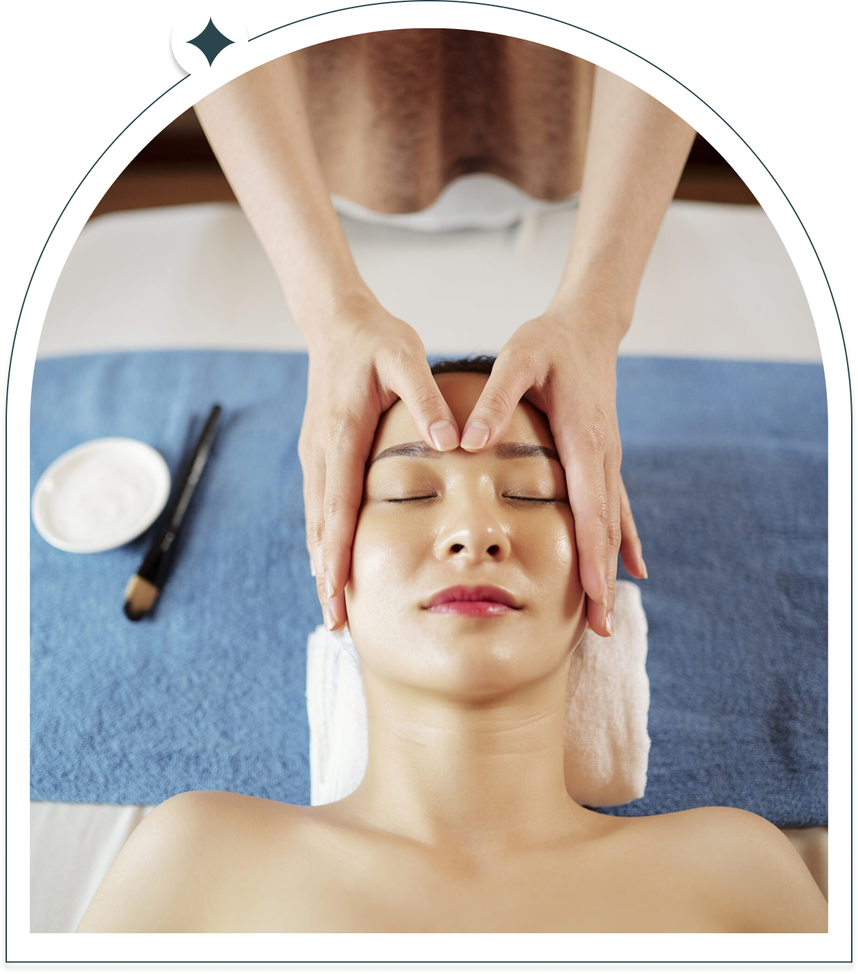 Relaxed woman receiving facial massage at spa