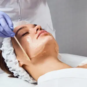 Woman receiving professional facial cream application