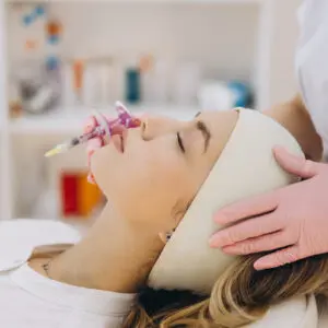 Woman receiving cosmetic lip filler injection