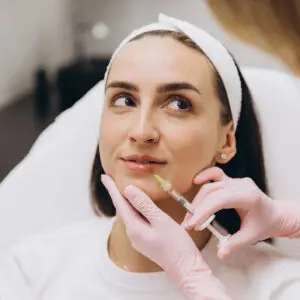 Woman receiving cosmetic facial filler injection