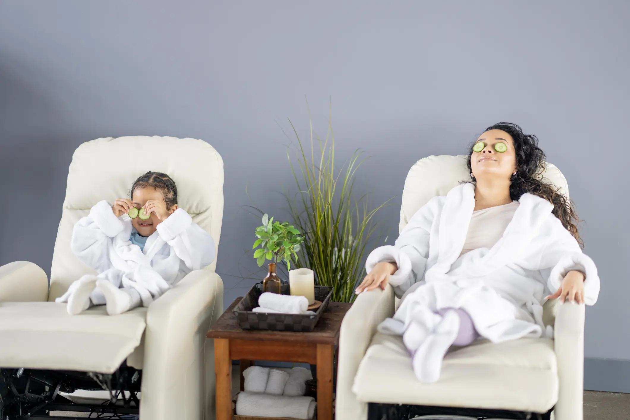 Woman and child relaxing in spa chairs