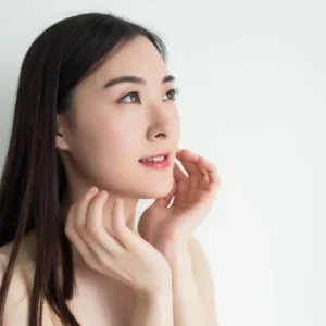 Smiling woman touching face, looking upward