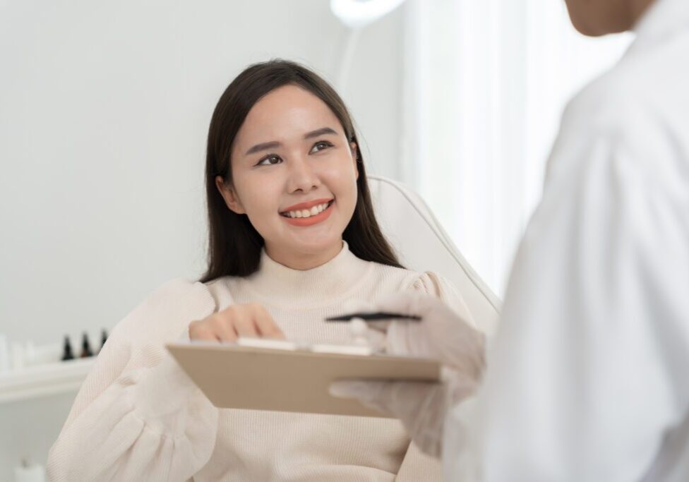 Smiling patient consulting doctor with clipboard